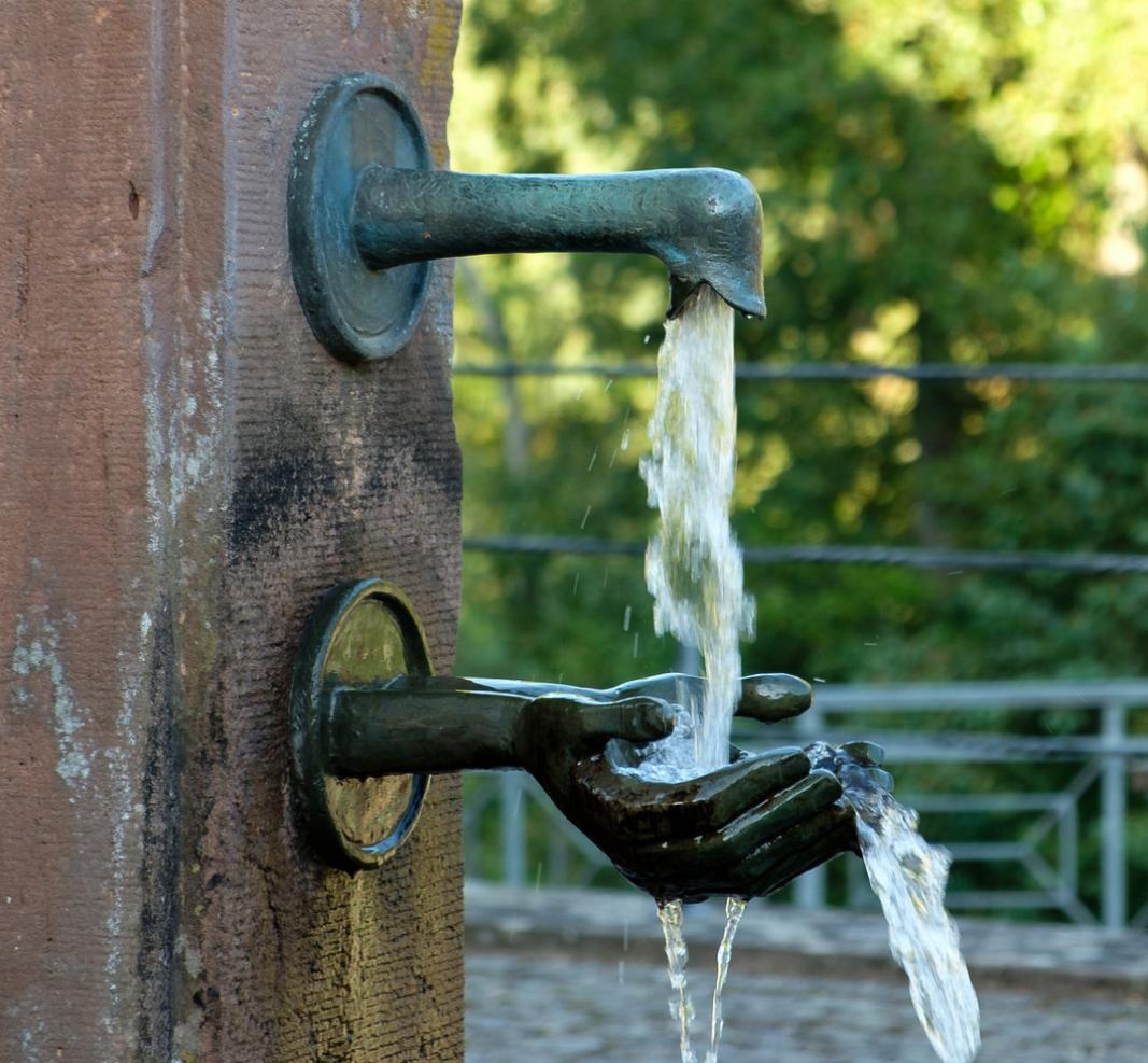Sprudelndes Wasser, das von einer Hand aufgenommen wird